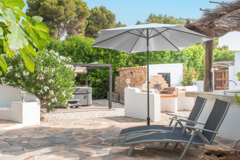 Can Petit's terrace sun loungers with the outdoor kitchen and pergola behind